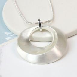 Peace Of Mind. Long silver plated necklace with a double hoop pendant featuring a cluster of silver plated rings, pink c